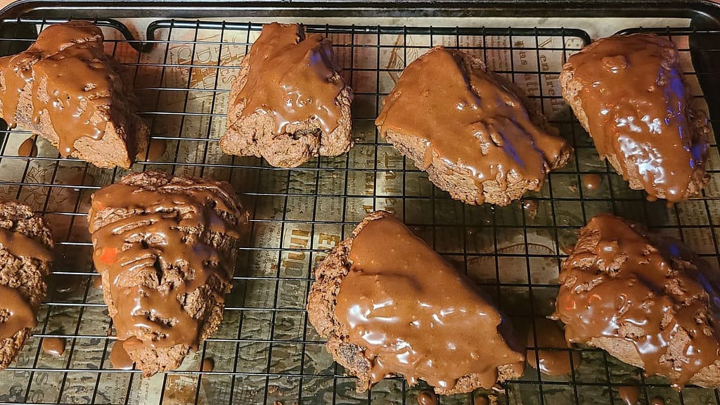 Double Chocolate Scones - Leslie Cooks
The scones are glazed with chocolate glazed. They are on a wire cooling rack