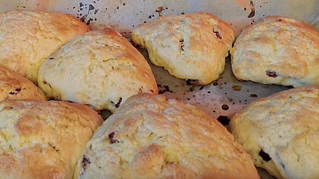 This image depicts baked cranberry scones as described by this blog post on lesliecooks.com. They are golden brown.