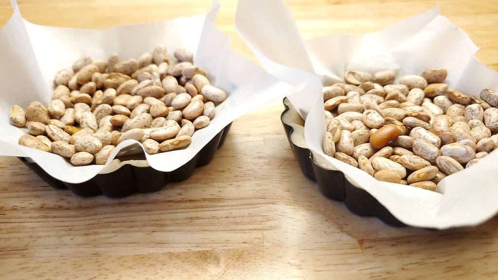 The image depicts beans being used as pie weights to help prevent dough shrinking as the tart shell bakes.