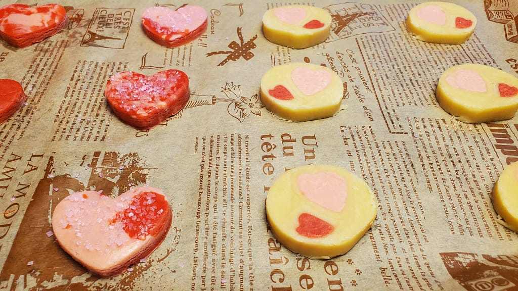 This image depicts unbaked cookies feature in this recipe blog. They are on some printed brown parchment paper.