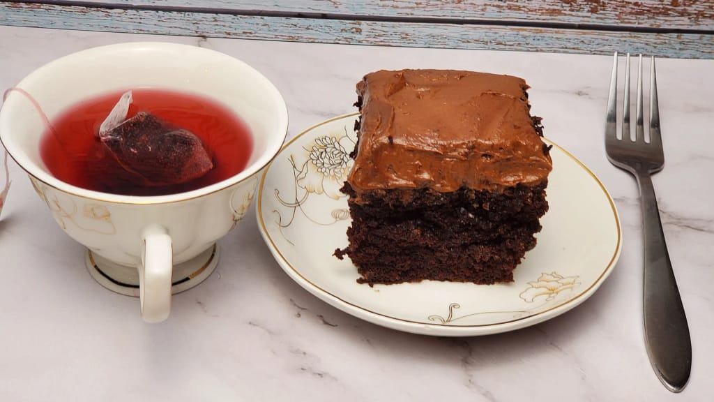 This image shows a piece of moist chocolate cake and a cup of hibiscus tea.