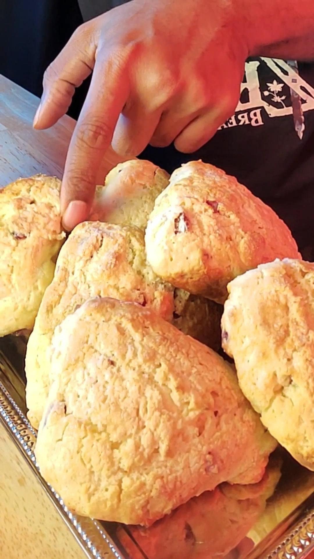 This image depicts cranberry scones being placed on a sliver plater. They are delicate and buttery.