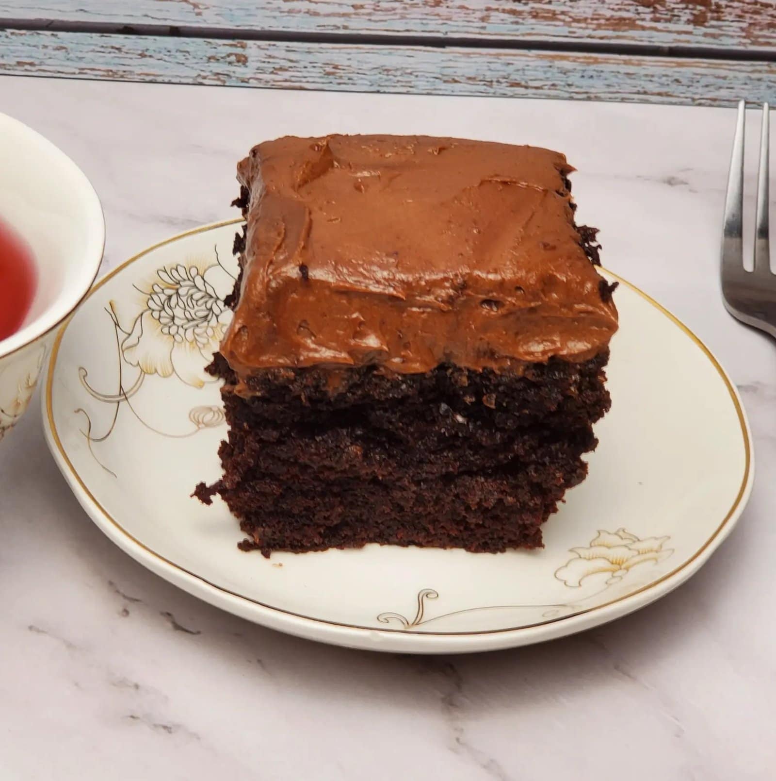 This image shows a piece of moist chocolate cake on a small plate.