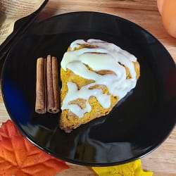 This image depicts a glazed pumpkin scone as described by this recipe on this blog post.