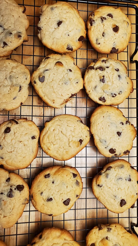 This image depicts sour cream chocolate chip cookies cooling on a cookie rack.