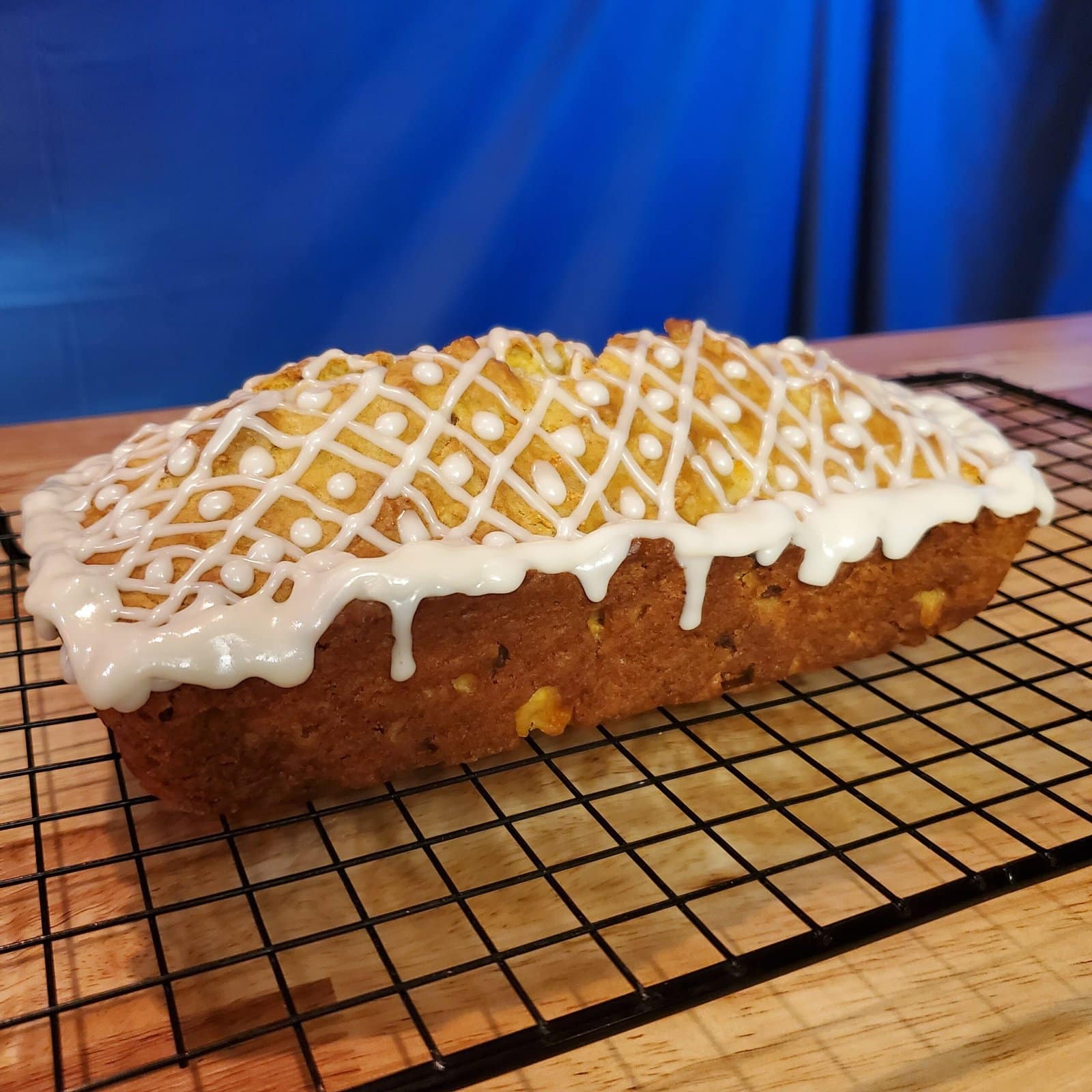 This image depicts iced apricot carrot bread. Icing is done in an intricate pattern.