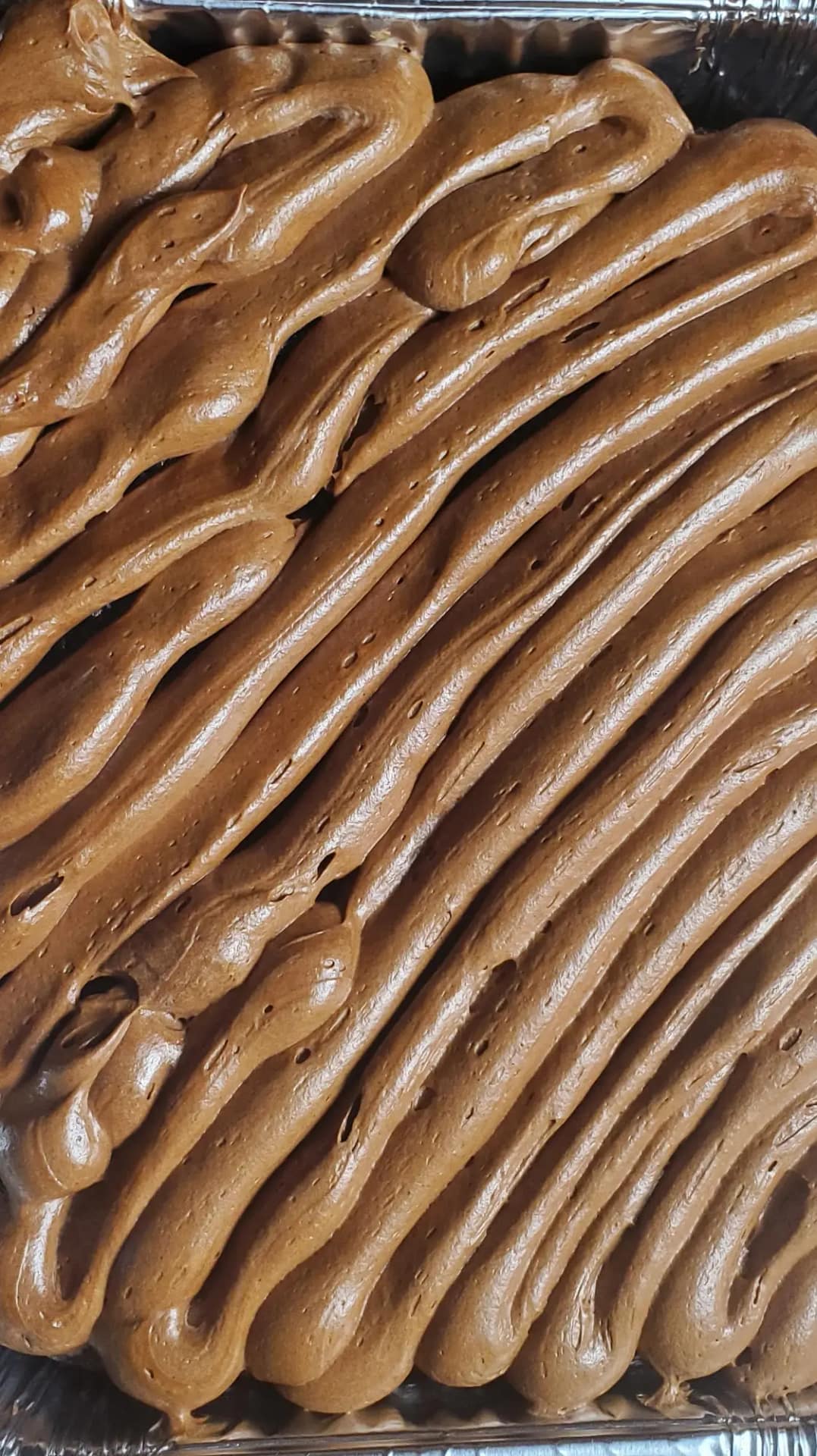 This image shows chocolate cream cheese frosting piped over a chocolate cake.