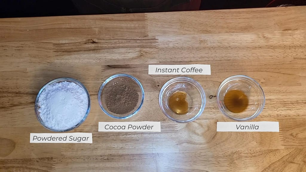 Double Chocolate Scone ingredients- This image depicts powdered sugar, cocoa powder, instant coffee, and vanilla extract