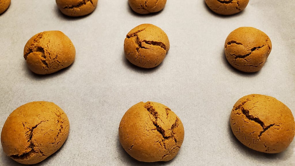 pfeffernusse 2 - Leslie CooksThis image depicts fully baker pfeffernusse as describes by this recipe blog. They are brown spice cookies. They are not currently iced in this picture.