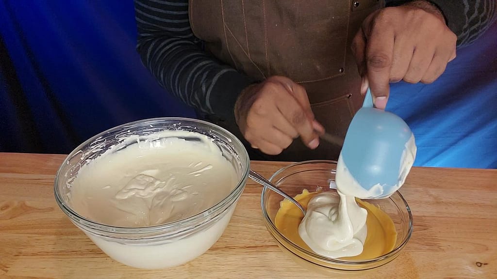 This image depicts cheesecake based being poured into chocolate.