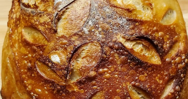 This picture depicts a boule of sourdough bread. It shows the results of follow the recipe on this page. The boule is golden brown with a nice crust.