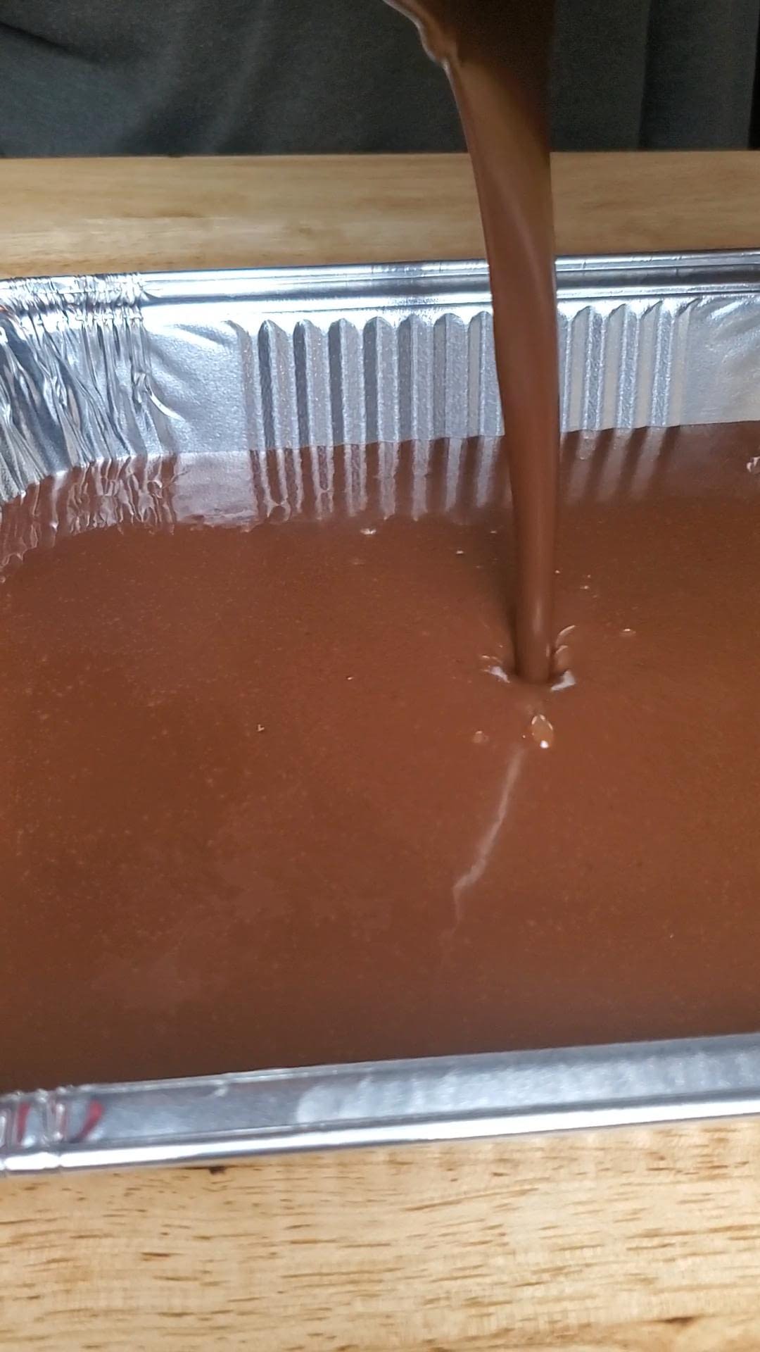 This image depicts cake batter being poured in baking tin.